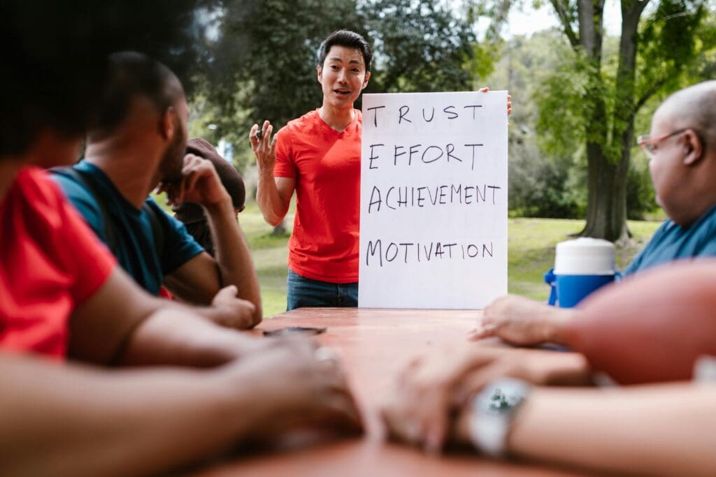 group of professionals sitting together at a picnic table going over team building activities at their company event